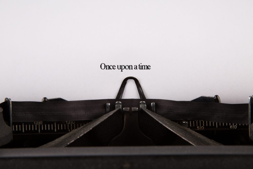 Photo of a typewriter with a sheet of paper with text that reads "Once upon a time."